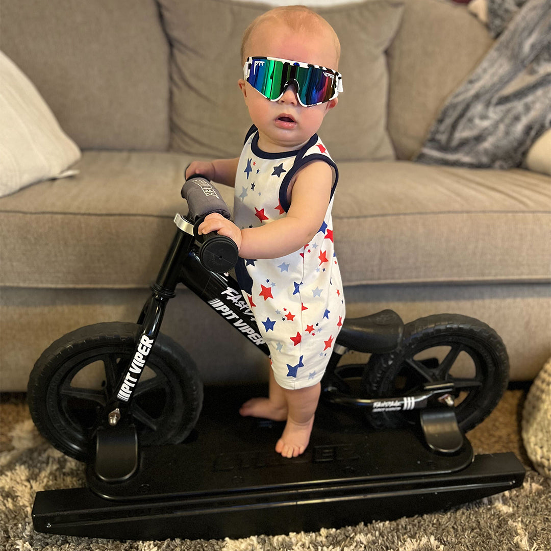 / Blue-Green | Baby on a stationary bike in The Cowabunga Baby Vipes from Pit Viper Sunglasses