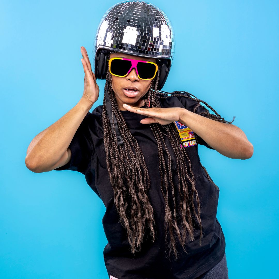 / Polarized Smoke | Women in disco ball helmet wears The Italo Flight Optics with a Polarized Smoke lens from Pit Viper Sunglasses