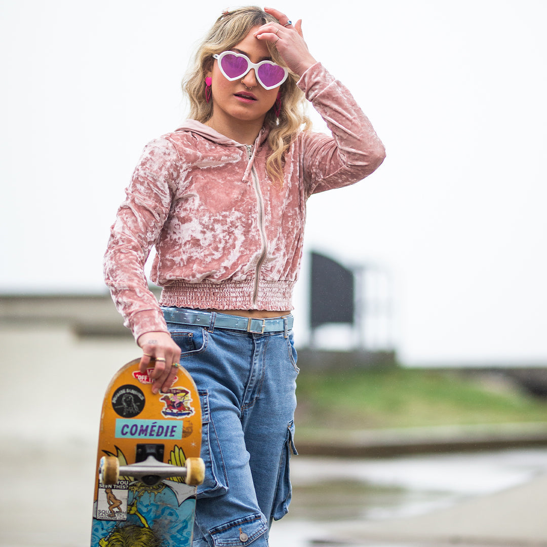 / Pink | Woman holding a skateboard in The Miami Nights Admirer from Pit Viper Sunglasses