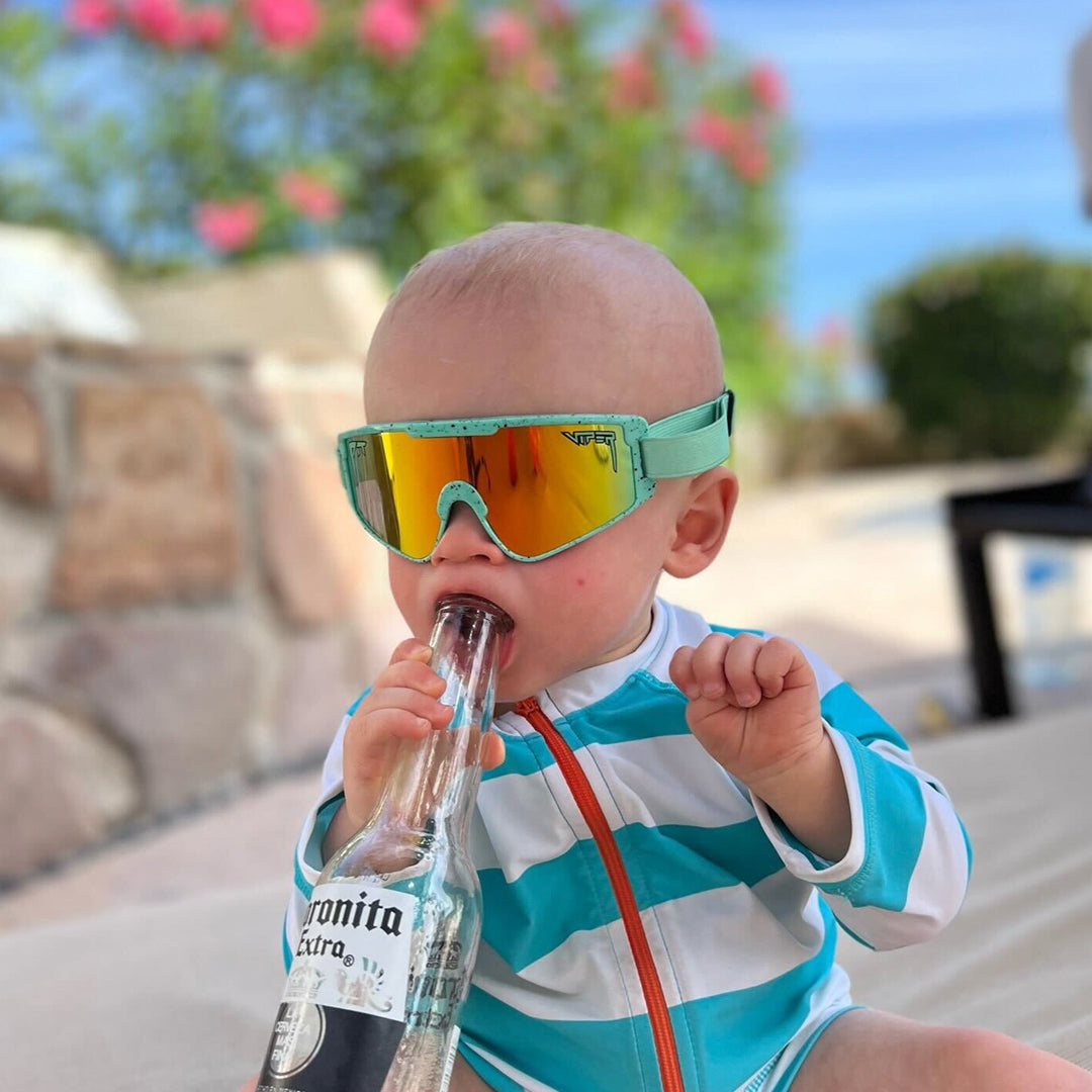 / Rainbow | Baby holding a beer bottle in The Poseidon Baby Vipes from Pit Viper Sunglasses