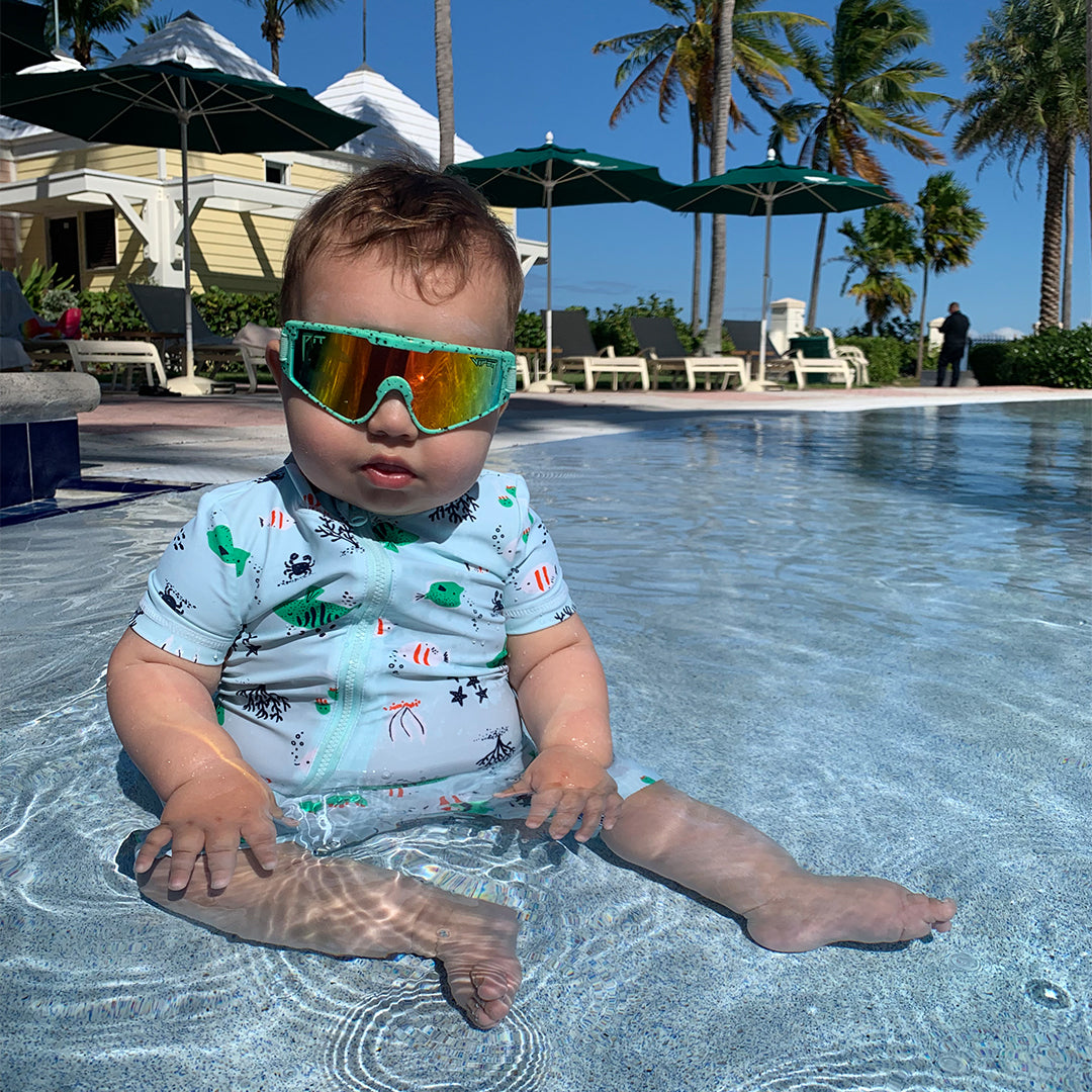 / Rainbow | Baby in a pool wearing The Poseidon Baby Vipes from Pit Viper Sunglasses