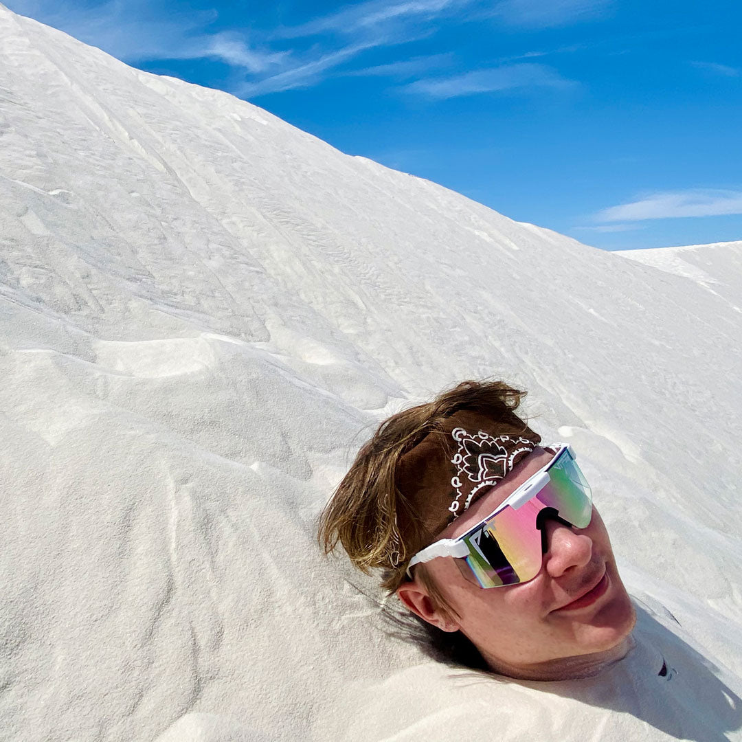 Wide / Pink Fade | Man in the sand wearing The Miami Nights Original from Pit Viper Sunglasses