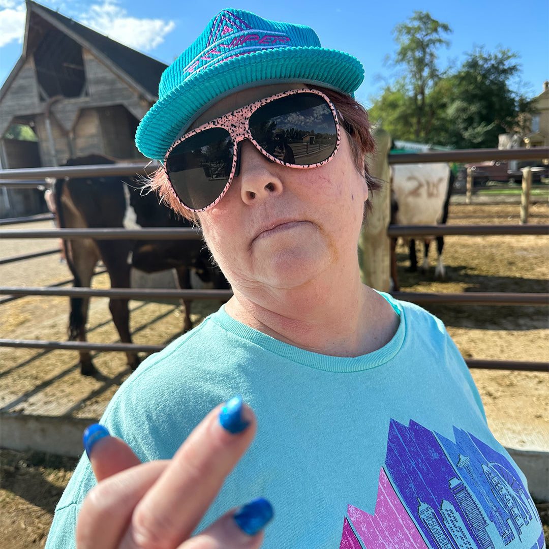 / Smoke | A woman flipping off the camera with horses wearing Pit Viper Sunglasses